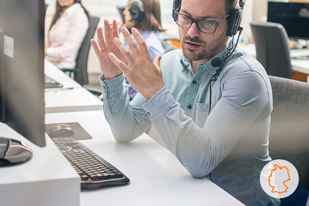 Servicerufnummern: Foto eines erklärenden CallCenter Agenten im Gespräch mit einem Kunden.