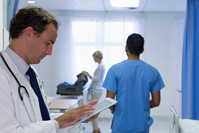 Arzt in einer Klinik tippt ins Tablet