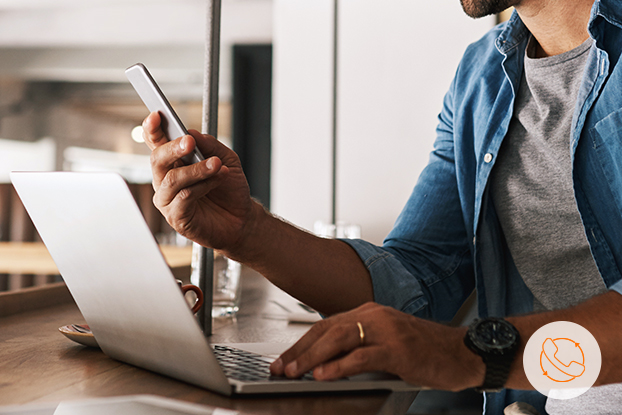 Das Foto eines Mannes bei der Arbeit mit Mobiltelefon und Notebook inkl. Telefonie und Internet mit der Selfcare Portal ecotel-at-once