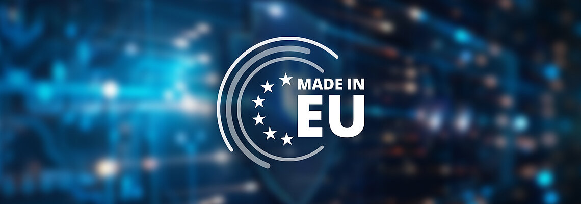 Weißes „Made in EU“-Logo mit Sternen und Kreisen auf unscharfem, blauem Hintergrund mit digitalen Lichtpunkten